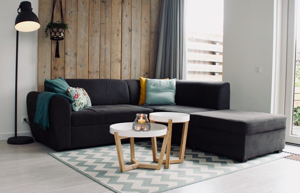 Szara kanapa narożna z kolorowymi poduszkami