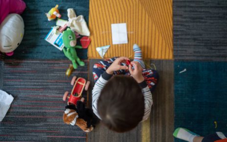 Chłopiec bawi się na dywanie zdalnie sterowanymi zabawkami