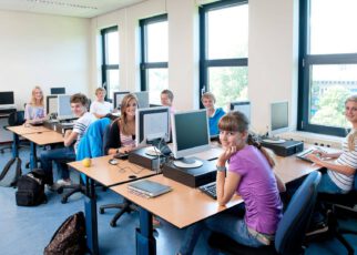 Uczniowie siedzą w nowoczesnej klasie na miarę XXI wieku przy podłodze interaktywnej