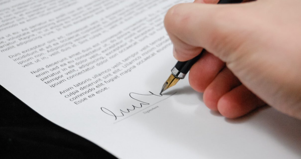 Mężczyzna podpisuje dokumenty dotyczące podziału majątku wspólnego